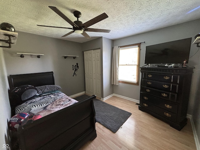 11720 Grenadier Ln, Indianapolis, IN 46229 - bedroom with light wood-type flooring, a closet, a ceiling fan, baseboards, and a textured ceiling