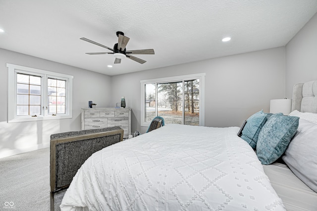 carpeted bedroom with multiple windows, ceiling fan, and a textured ceiling