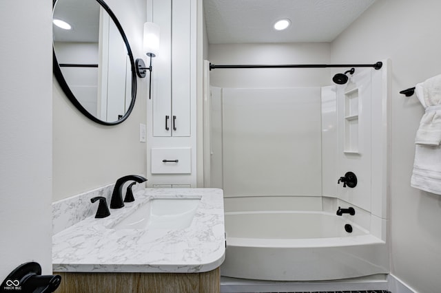 bathroom with shower / bathtub combination, vanity, and a textured ceiling