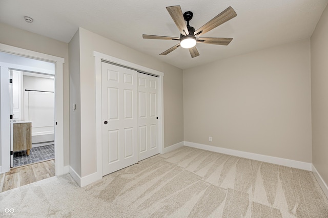 unfurnished bedroom with light carpet, a closet, and ceiling fan