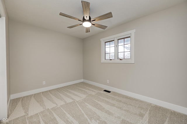 carpeted spare room featuring ceiling fan