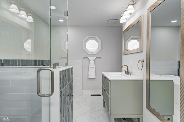 bathroom with vanity and a shower with door