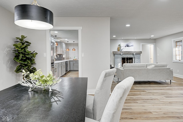 dining space with a fireplace and light hardwood / wood-style flooring