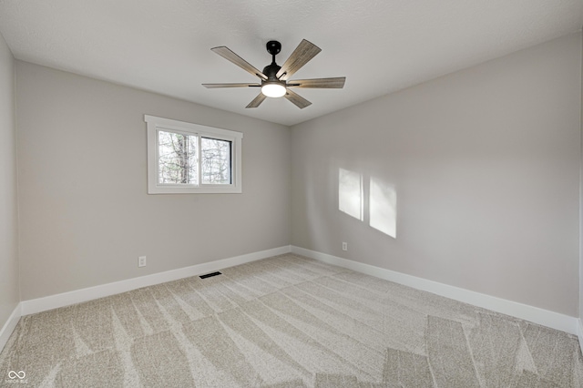 unfurnished room with ceiling fan and light colored carpet