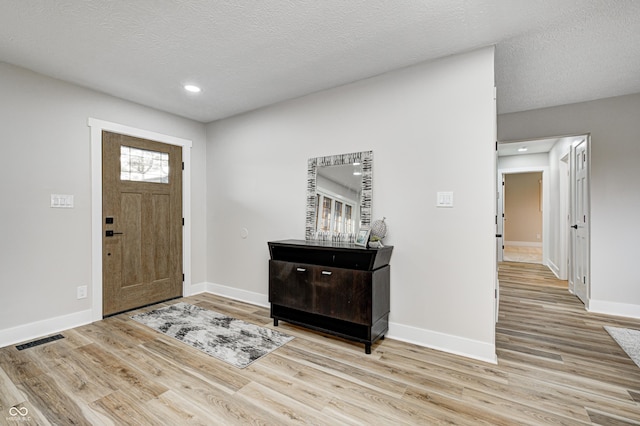 foyer featuring a textured ceiling and light hardwood / wood-style flooring