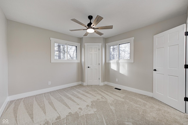 unfurnished bedroom featuring light colored carpet and ceiling fan