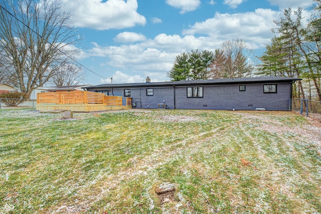 rear view of property with a yard, a wooden deck, and central AC