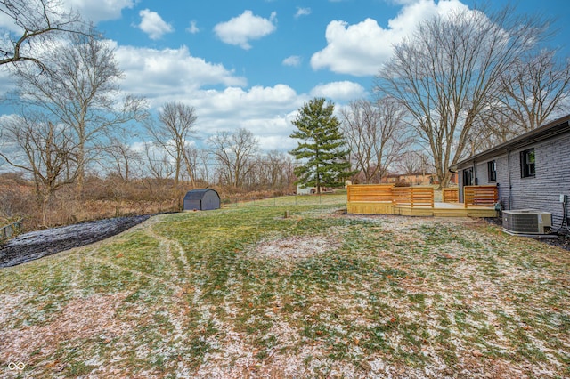 view of yard featuring central AC unit, a storage shed, and a deck