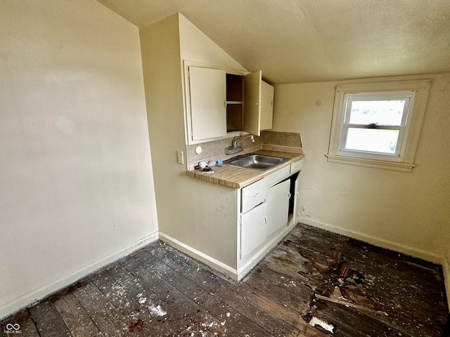 kitchen featuring dark hardwood / wood-style flooring, white cabinetry, sink, and lofted ceiling