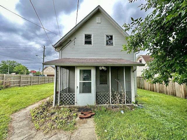 rear view of property with a yard