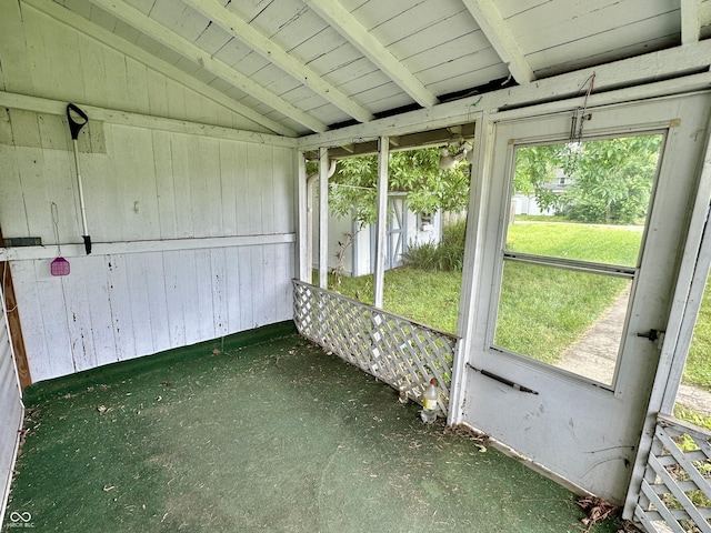 unfurnished sunroom with vaulted ceiling with beams and a wealth of natural light