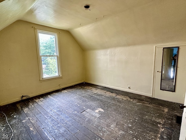 additional living space featuring dark hardwood / wood-style flooring and vaulted ceiling