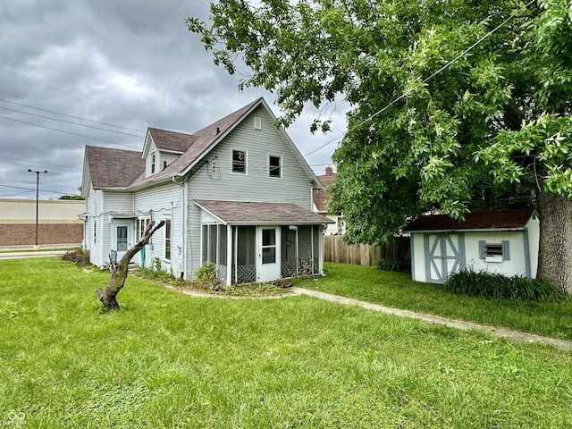 back of house with a lawn and a storage shed