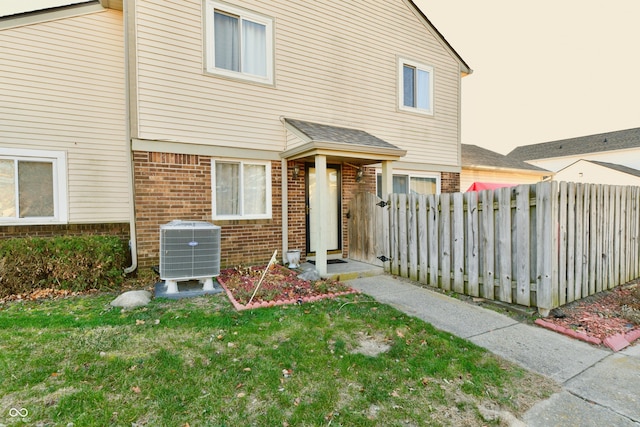 view of front of property with central AC and a front lawn