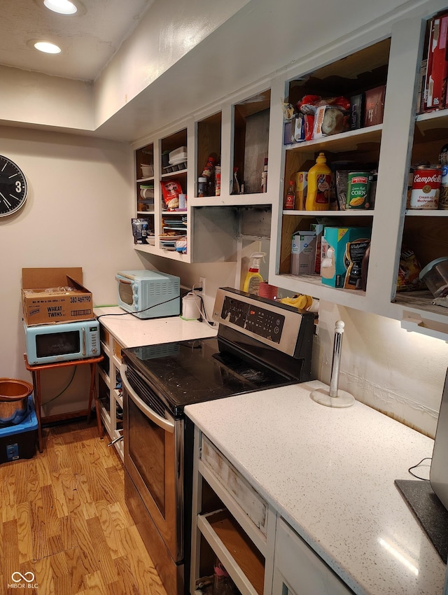 kitchen with light wood-type flooring and range with electric stovetop