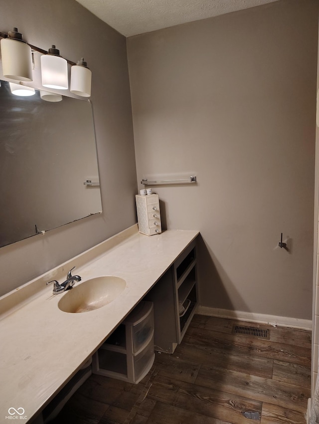 bathroom featuring vanity, hardwood / wood-style floors, and a textured ceiling