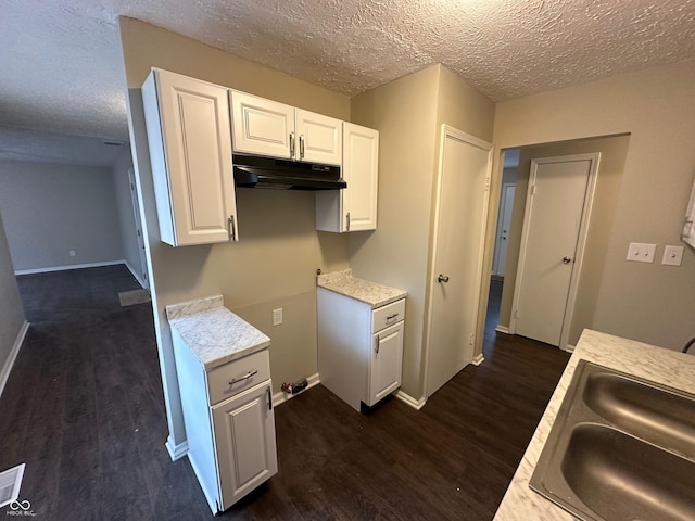 kitchen with white cabinets, sink, and a textured ceiling