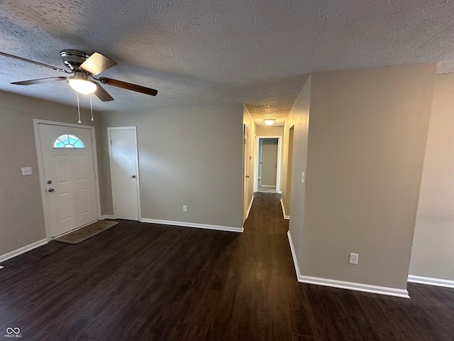 foyer entrance with ceiling fan, dark wood-type flooring, and a textured ceiling