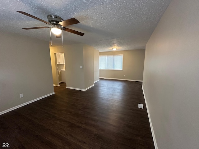 empty room featuring a textured ceiling, ceiling fan, and dark hardwood / wood-style floors