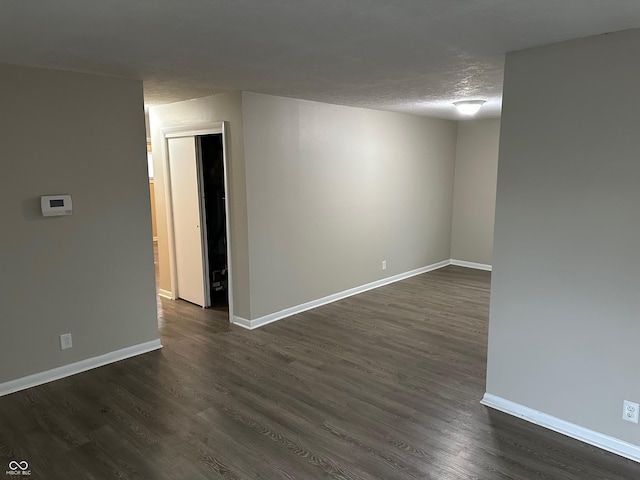 empty room featuring dark hardwood / wood-style floors and a textured ceiling