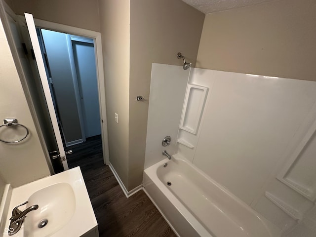 bathroom featuring hardwood / wood-style floors, vanity, shower / bath combination, and a textured ceiling