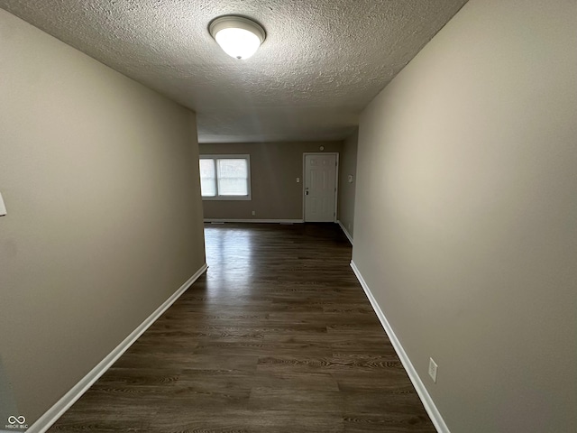 hallway featuring a textured ceiling and dark hardwood / wood-style floors