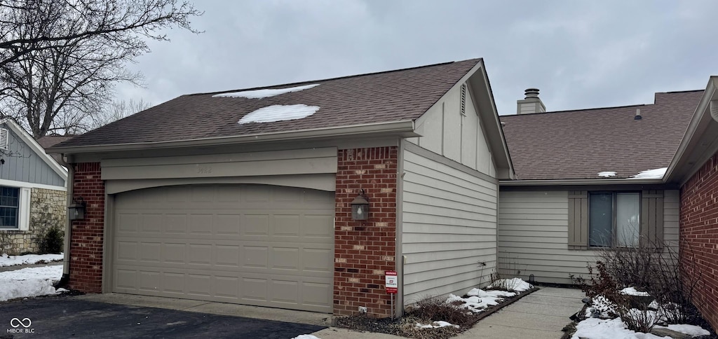 snow covered property featuring a garage