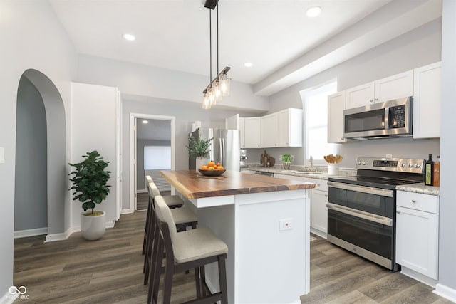 kitchen featuring wooden counters, stainless steel appliances, and white cabinets