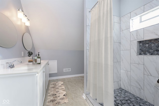 bathroom with tile patterned flooring, vanity, and walk in shower