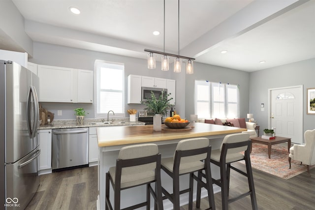 kitchen featuring sink, dark wood-type flooring, white cabinets, a kitchen island, and appliances with stainless steel finishes