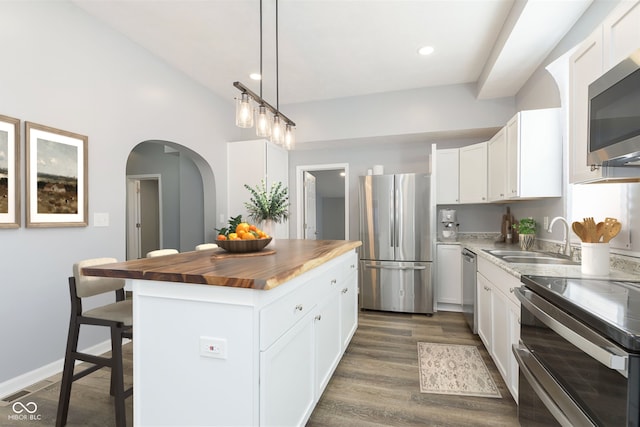 kitchen featuring white cabinets, dark hardwood / wood-style floors, a center island, and stainless steel appliances