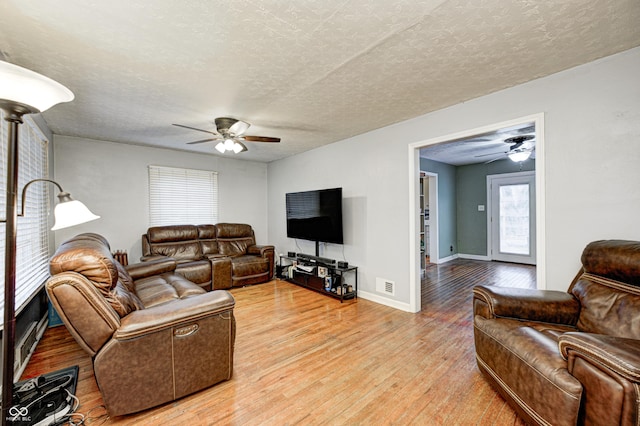 living room featuring a textured ceiling and light hardwood / wood-style flooring