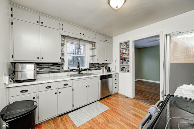 kitchen with backsplash, sink, dishwasher, and light hardwood / wood-style flooring