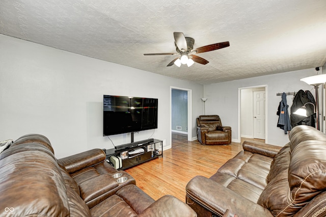 living room with hardwood / wood-style floors, ceiling fan, and a textured ceiling