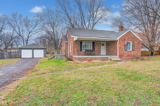 view of front of home with a front yard, a porch, a garage, and an outdoor structure