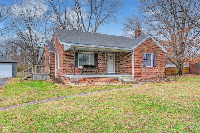 view of front of home featuring a garage, a front lawn, and an outdoor structure