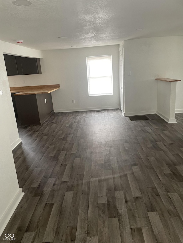 unfurnished living room with dark wood-type flooring