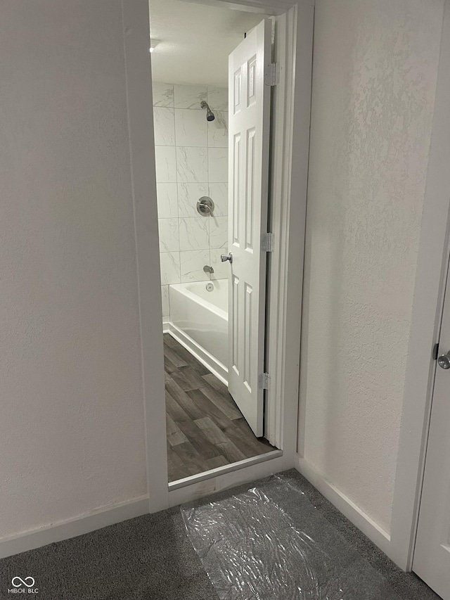 bathroom with hardwood / wood-style flooring and tiled shower / bath