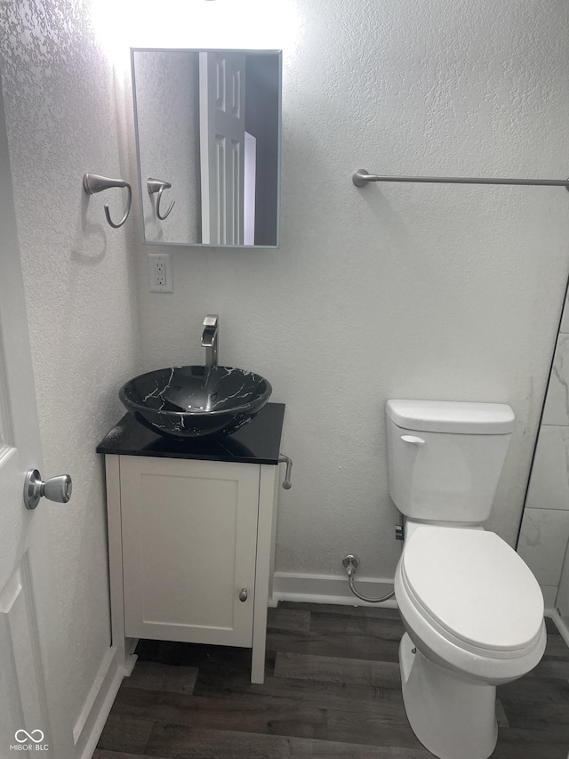 bathroom featuring toilet, vanity, and hardwood / wood-style flooring