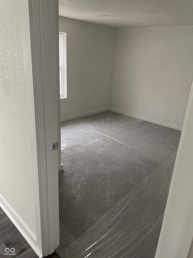 spare room with dark hardwood / wood-style flooring and a textured ceiling