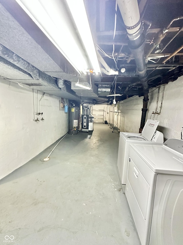unfinished below grade area featuring separate washer and dryer and gas water heater