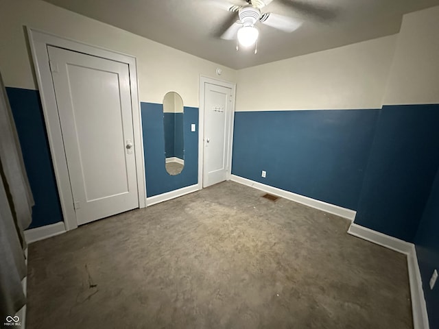 unfurnished bedroom featuring a ceiling fan, concrete floors, baseboards, and visible vents