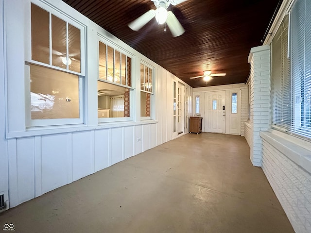 unfurnished sunroom featuring a ceiling fan