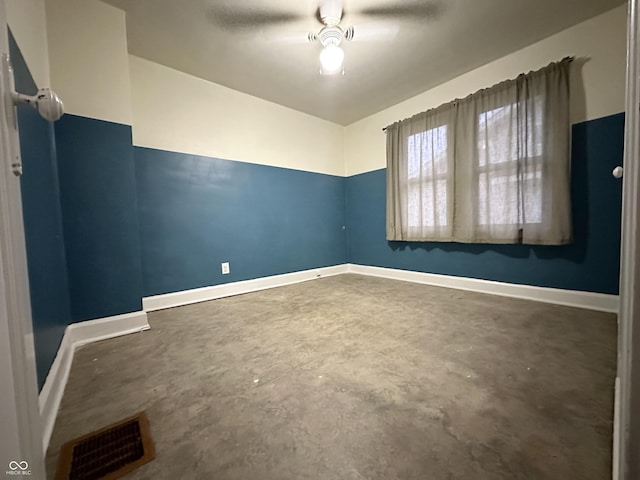 spare room featuring baseboards, unfinished concrete flooring, ceiling fan, and visible vents