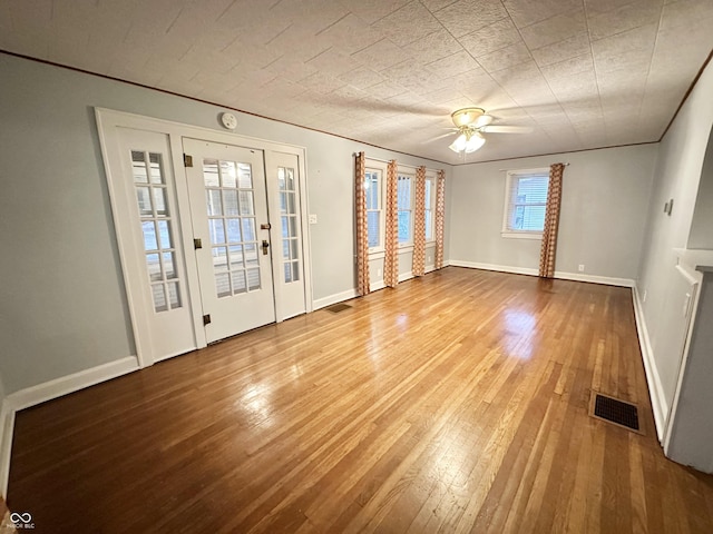 interior space with baseboards, visible vents, and wood-type flooring