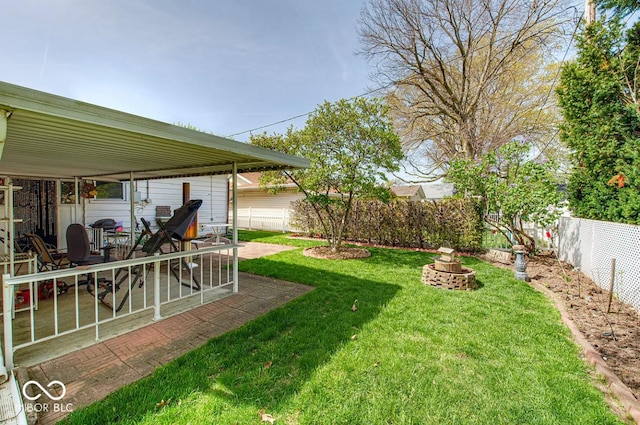 view of yard with a fenced backyard, a fire pit, and a patio