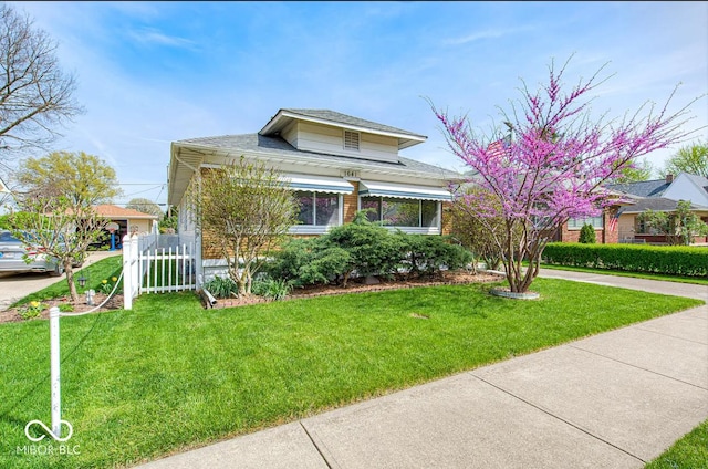 view of front of house with a front yard, driveway, and fence