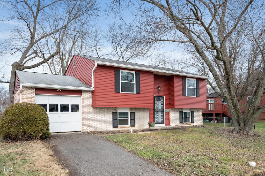 bi-level home featuring a garage and a front yard