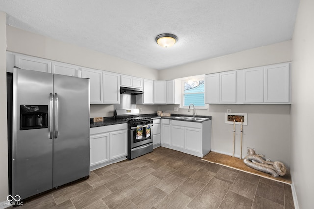 kitchen with appliances with stainless steel finishes, sink, white cabinets, and a textured ceiling