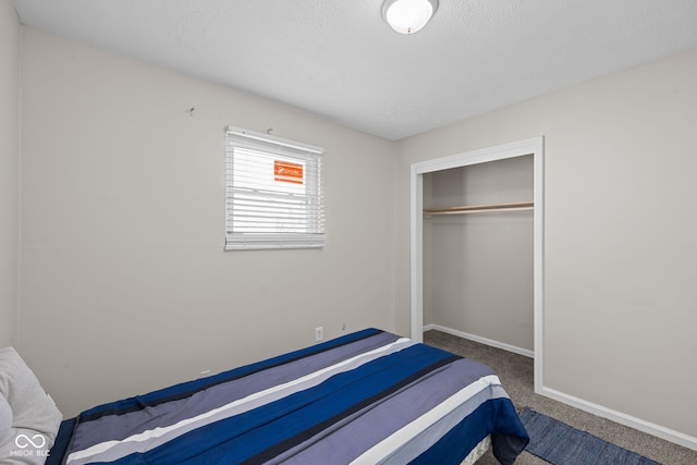 carpeted bedroom featuring a textured ceiling and a closet